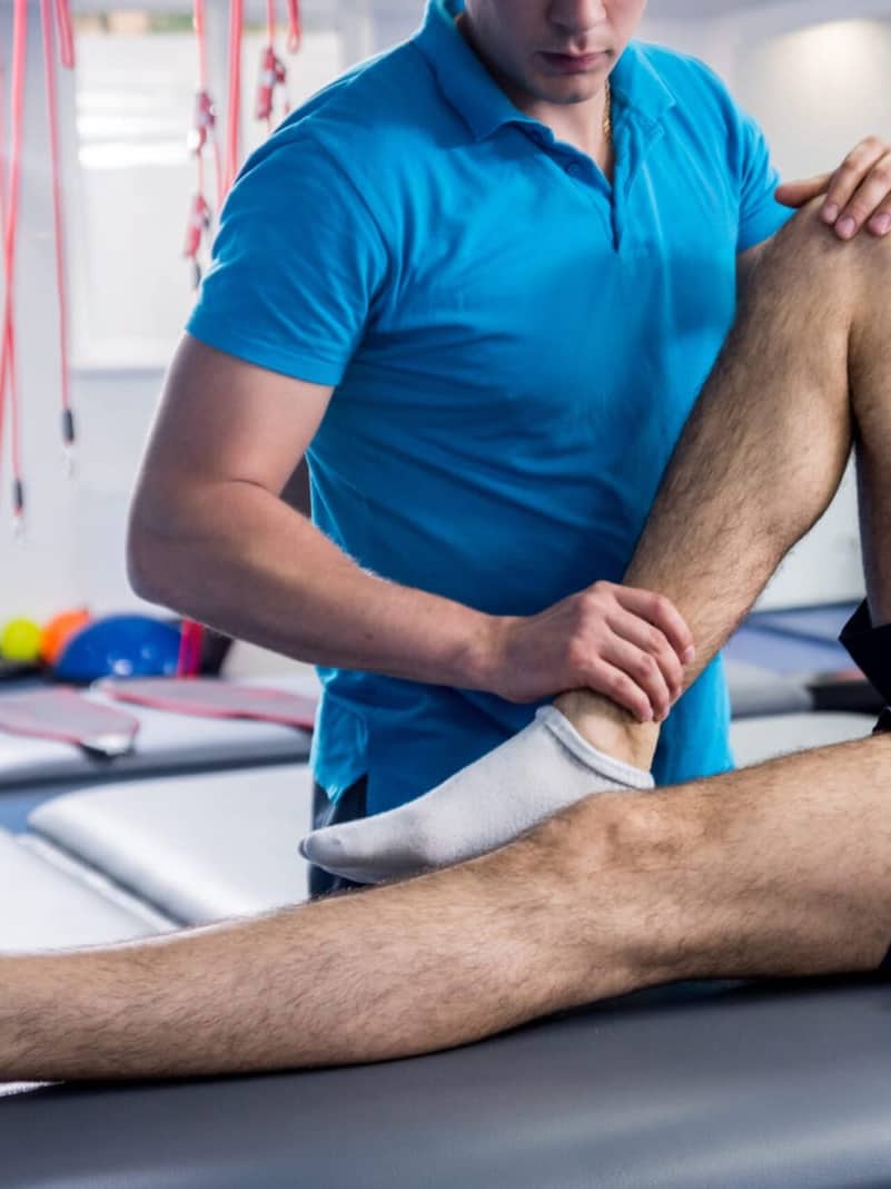 Fisioterapeuta aplicando terapia manual sobre el hombro de una paciente